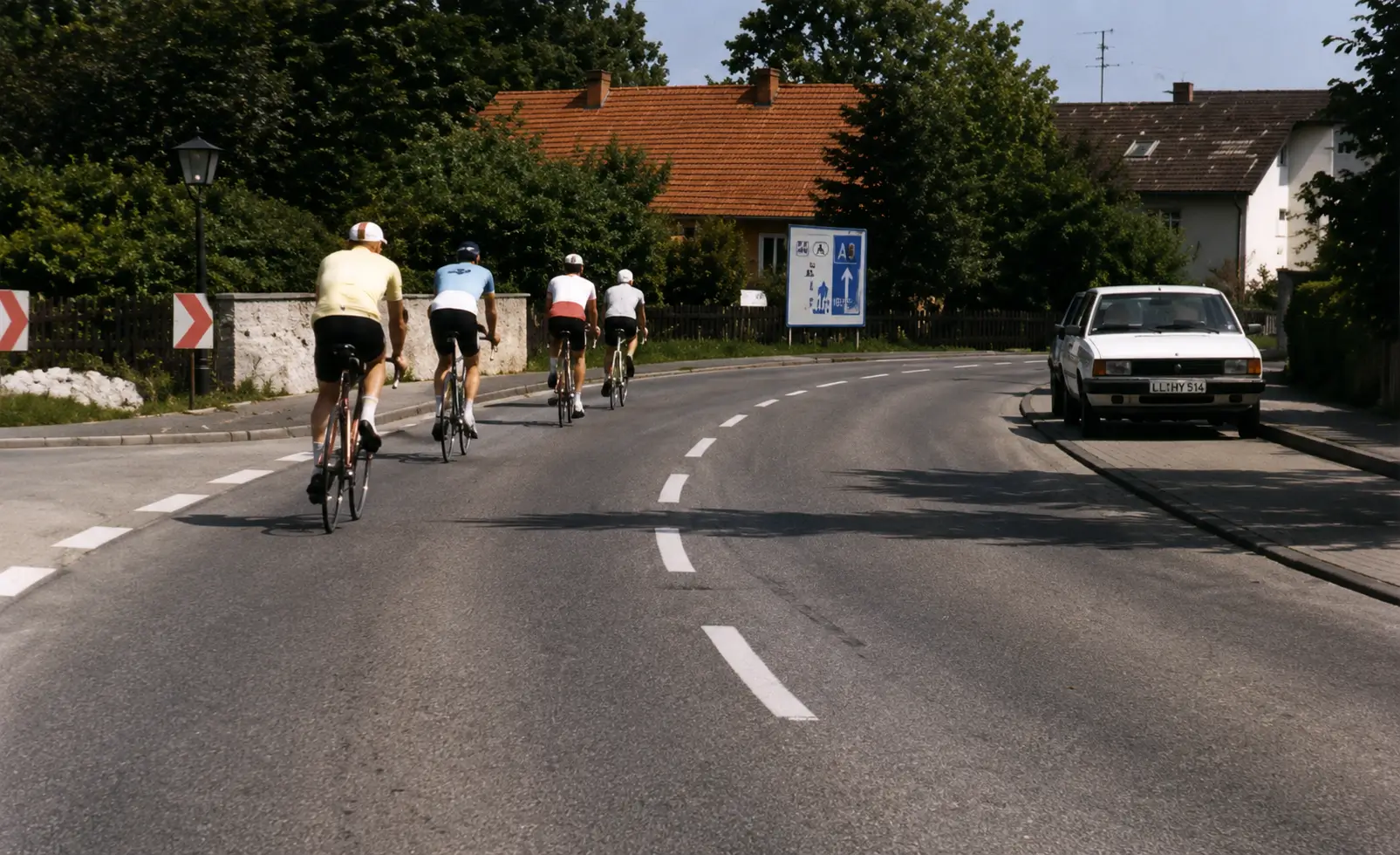 Cyclists on road with car behind
