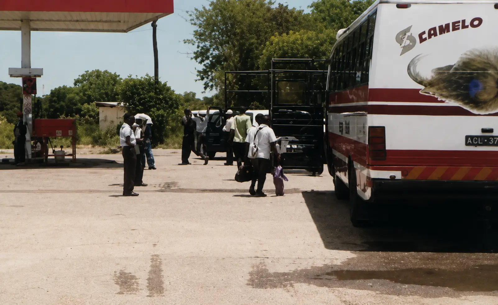 Photo of stationary bus at petrol station with people around
