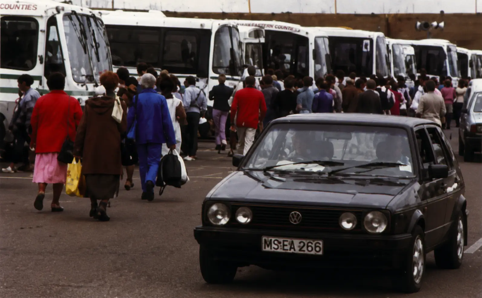 Photo of busy bus stop with pedestrians and car