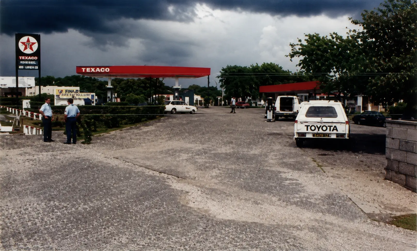 Photo of road near petrol station with pedestrians