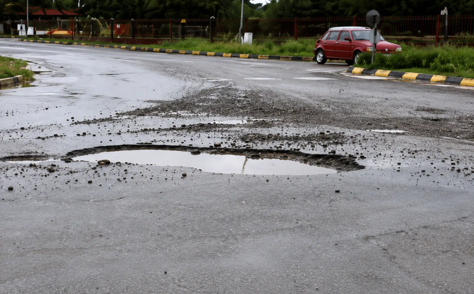 Photo of road with pothole and puddle