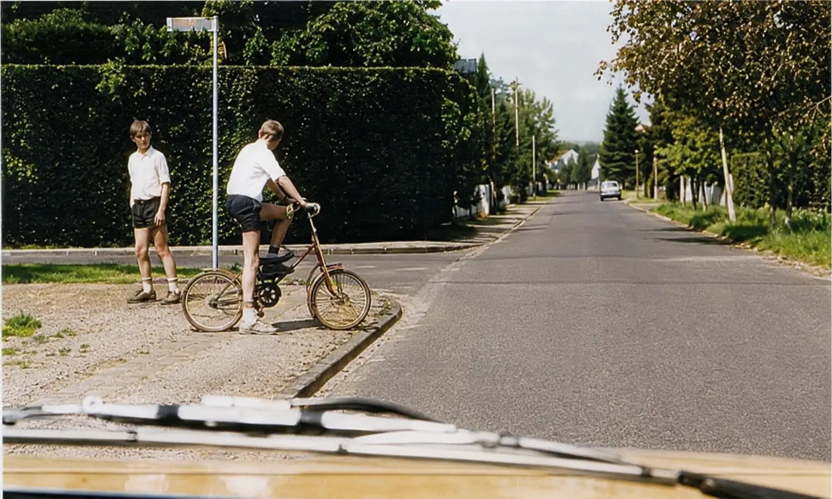 Photo of boy on bike at roadside with another child
