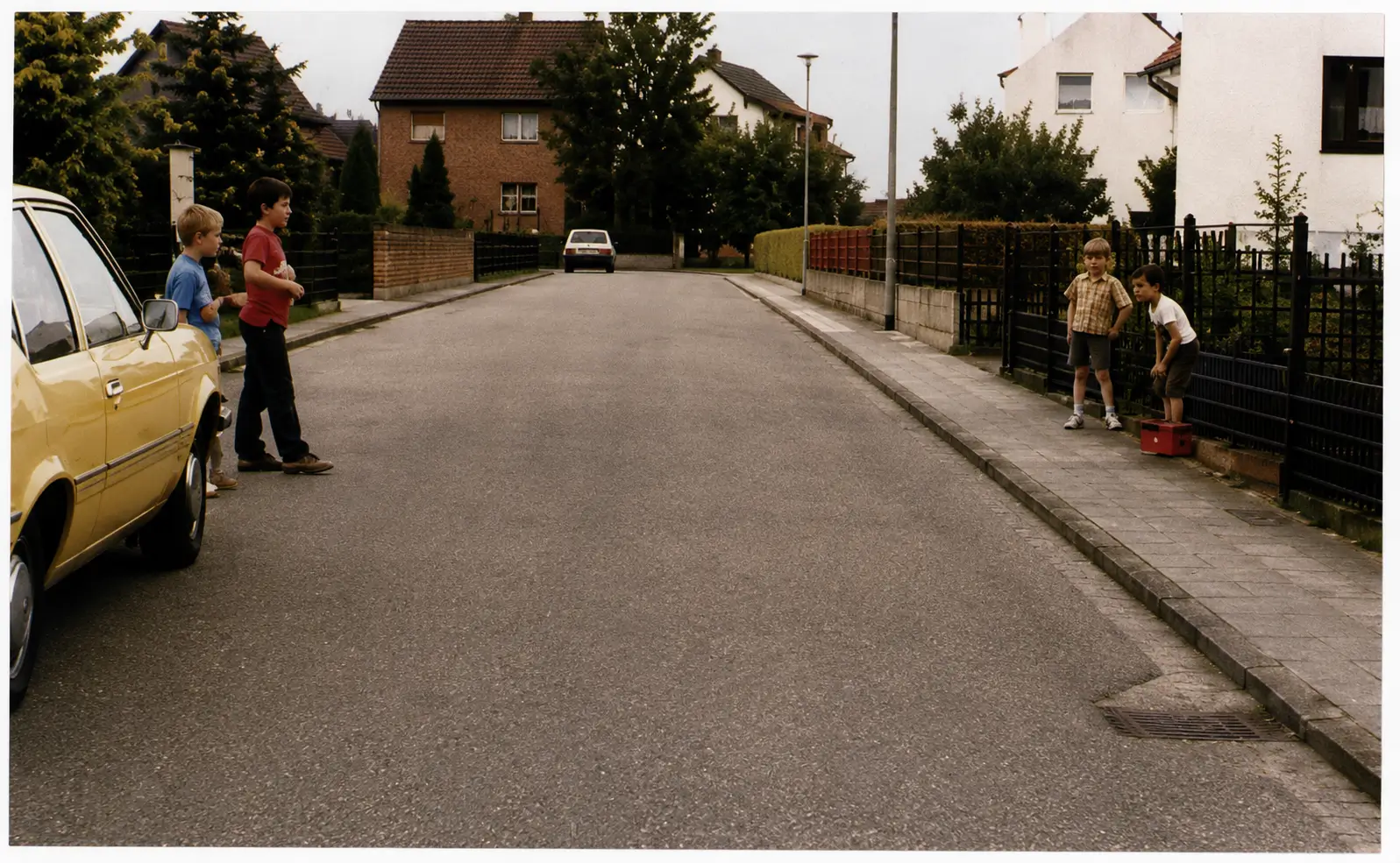 Photo of children near parked car on roadside