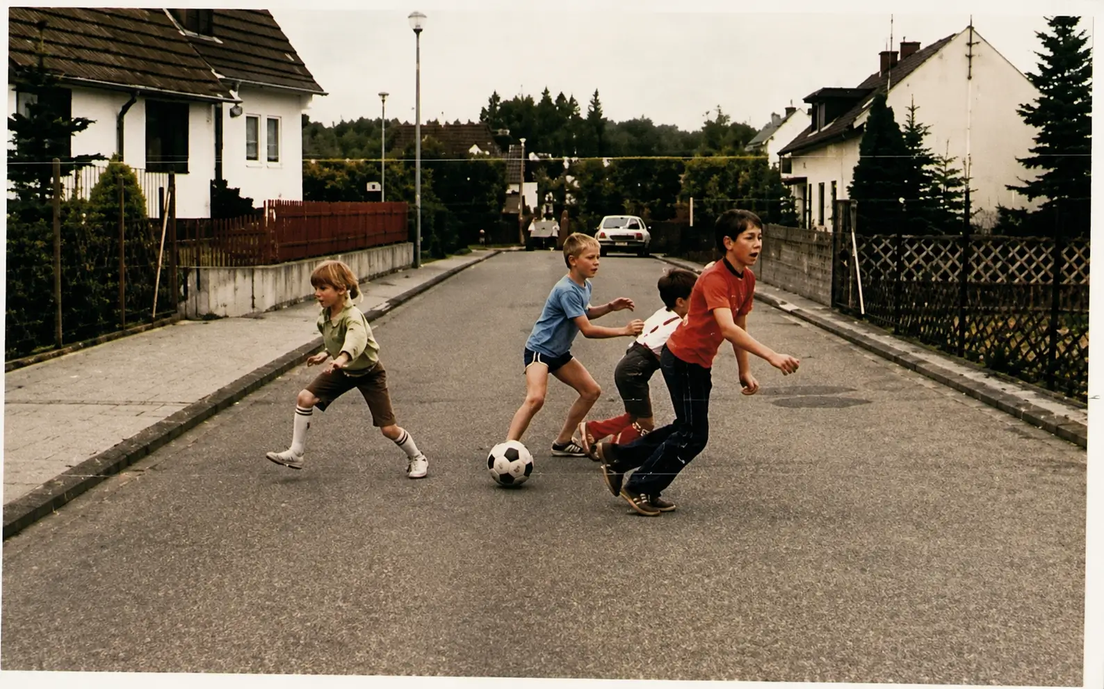 Photo of children playing football on road