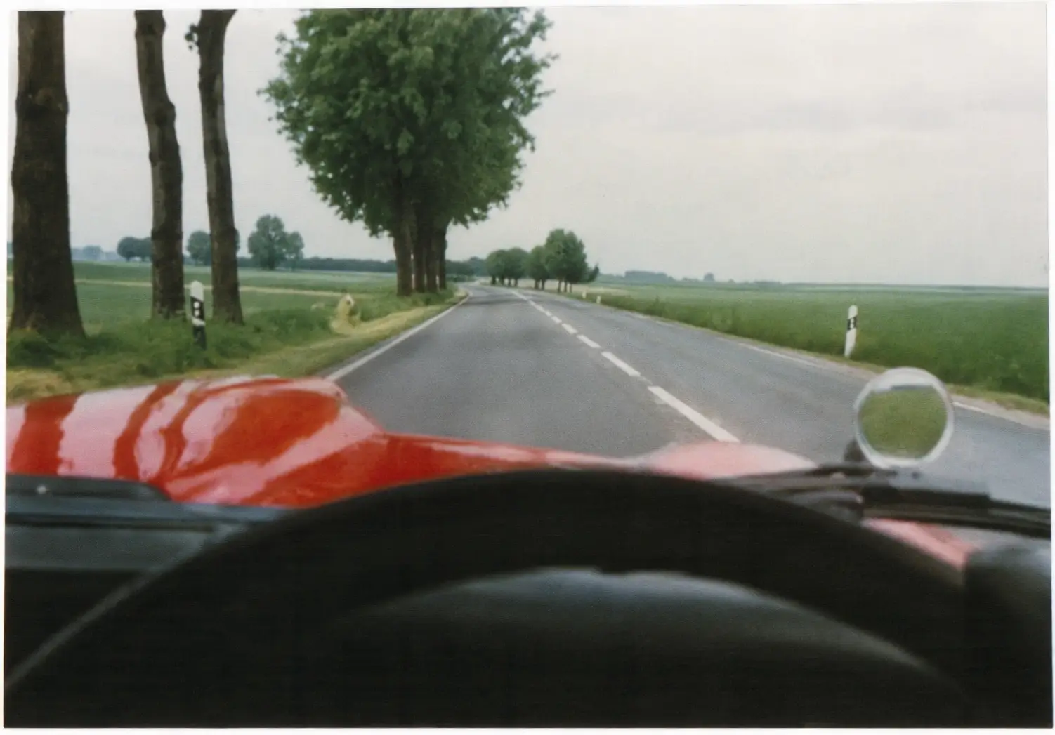 Photo of road with orange traffic cones and solid centre line