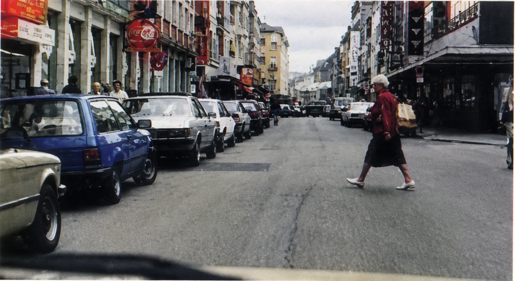Picture of a woman crossing a road between parked cars