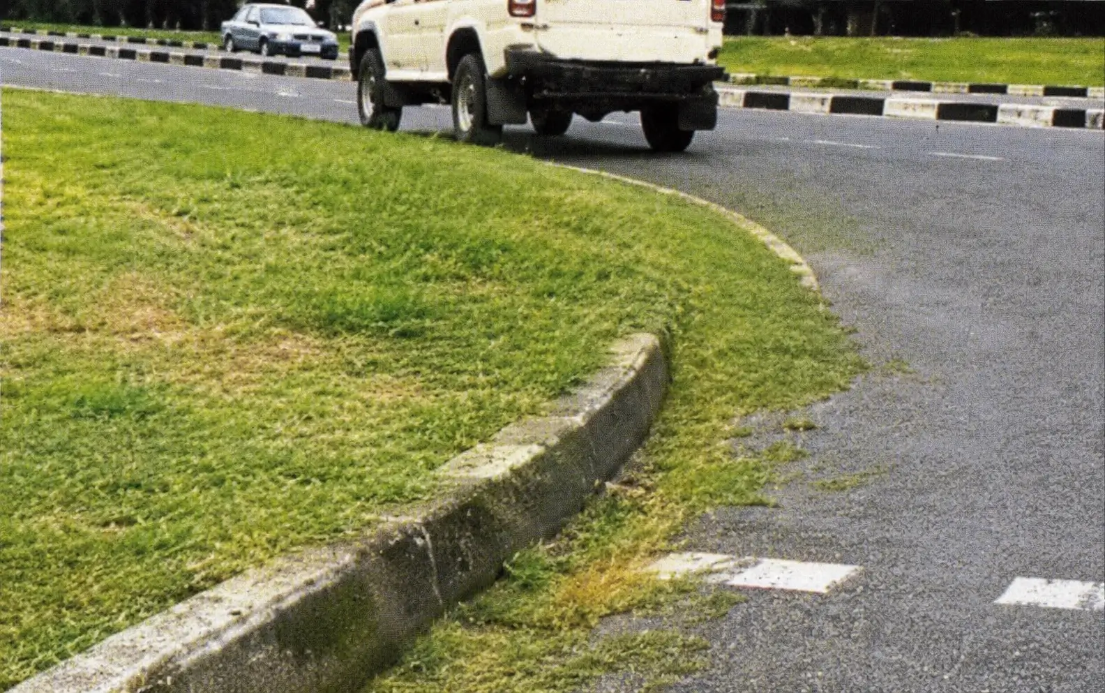 a tight bend with grass getting on the road