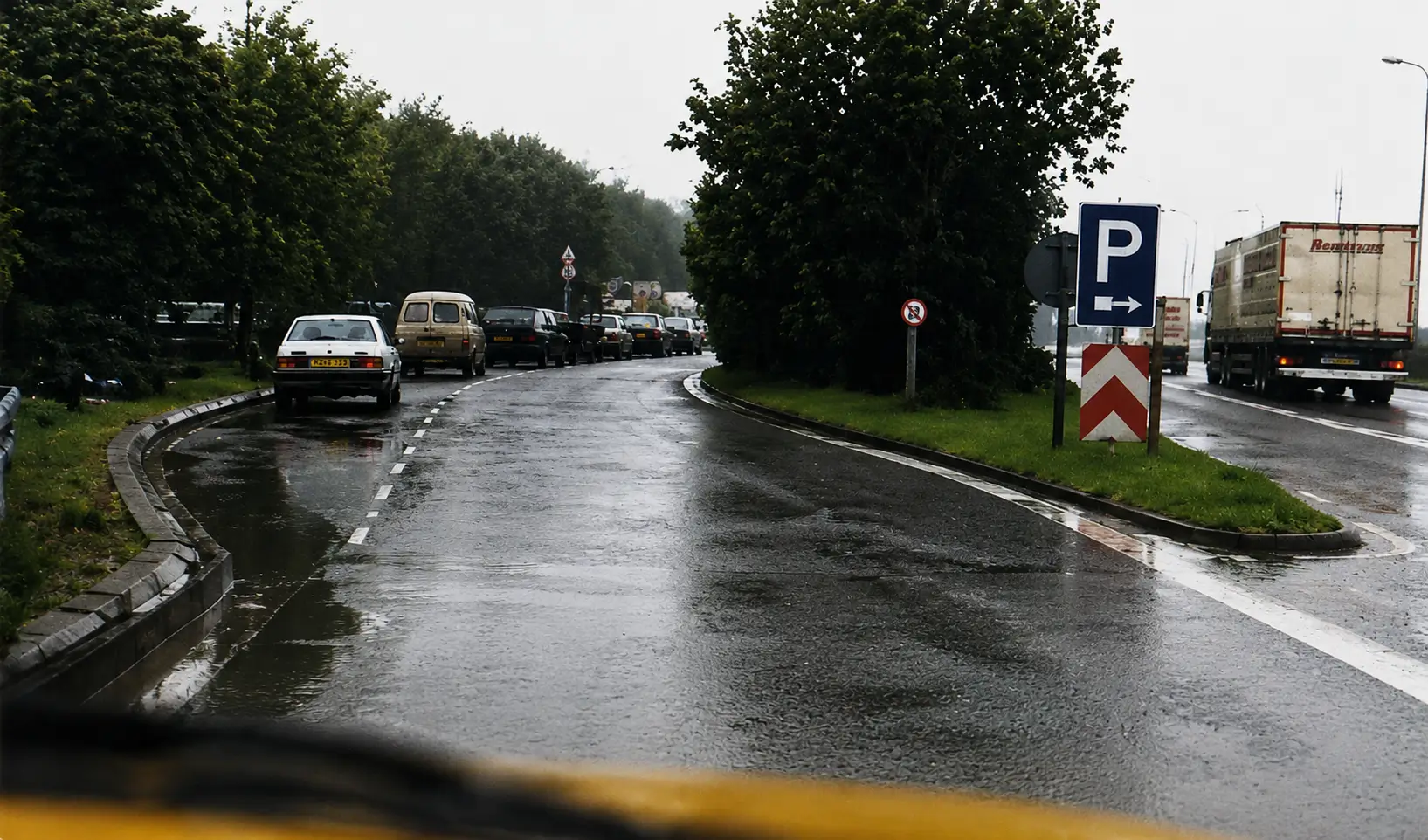 cars parked on the side on a wet road